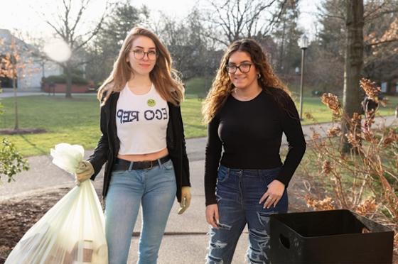 Photo of two Chatham University students, one wearing an Eco Reps shirt, collecting trash on Shadyside Campus